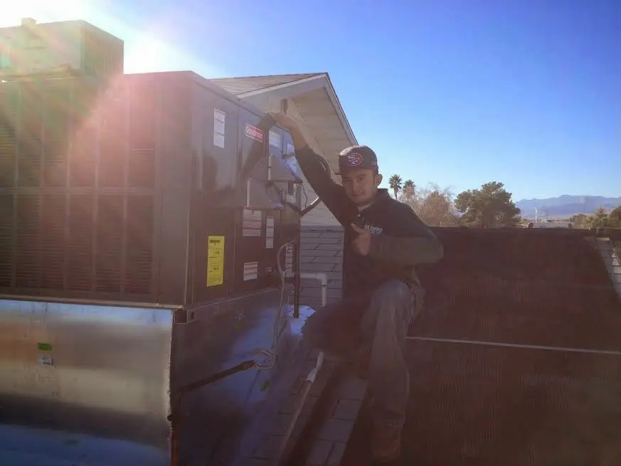 HVAC technician performing Heat Pump Repair on a rooftop unit in Pound Ridge